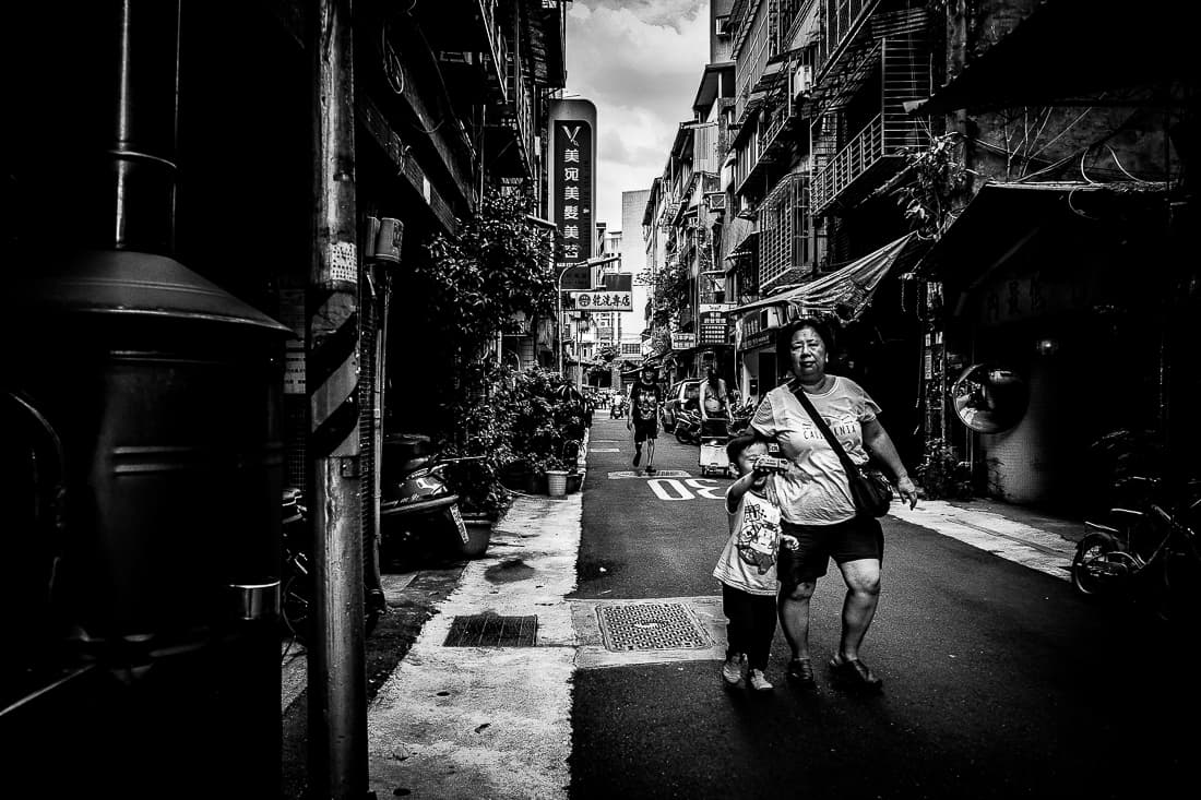 Stout mother and her little son walking lane