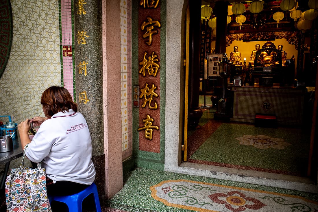 Woman having lunch in front of temple
