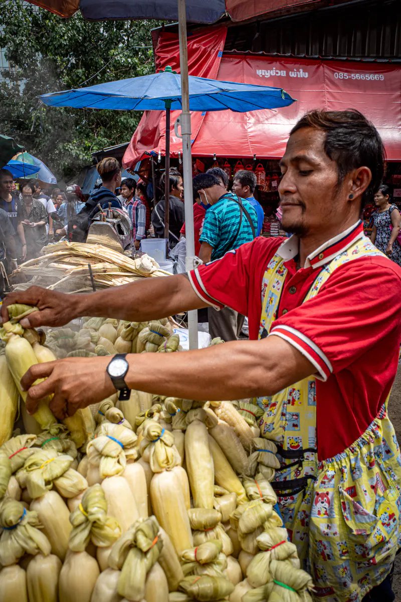 Man selling steamed corns in Khlong Toei Market