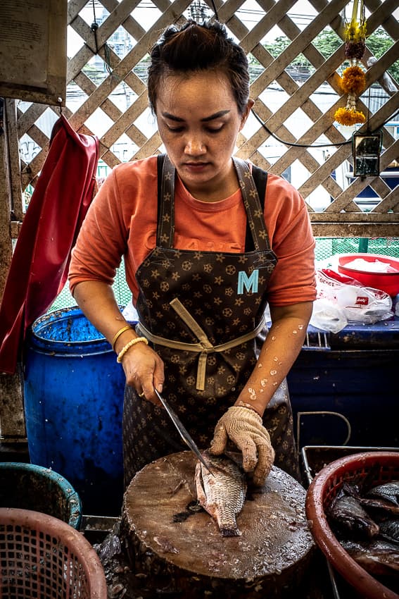 Woman wearing a Louis-Vuitton-like apron in Khlong Toei Market