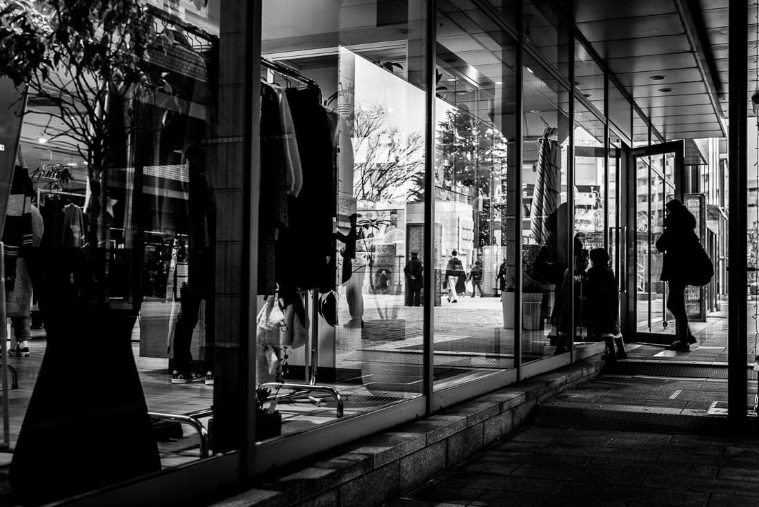 Glass-walled shop and silhouetted woman