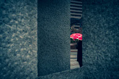 オブジェの向こう側を歩く花柄の傘を差す女性