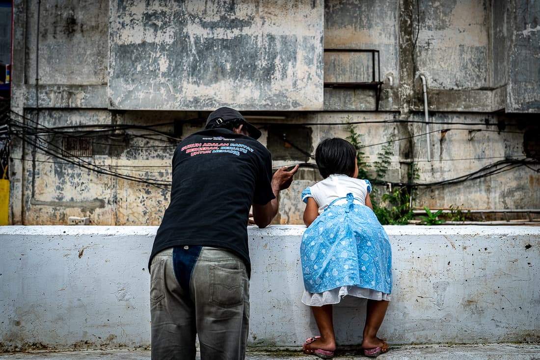 Old man and his grandchild watching the waterway together