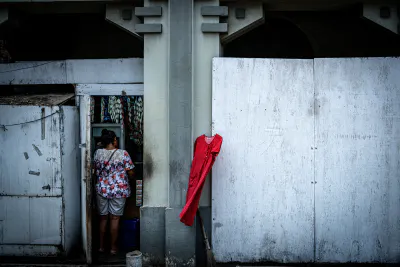 ジャカルタの町角の壁にかかる赤いワンピース