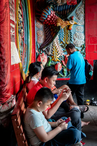 Young men playing a phone game in Jin De Yuan
