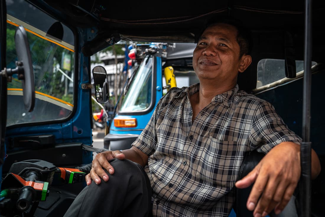 Bajaj driver wearing a checkered shirt