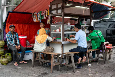 Big food stall on the side of the wide street in Jakarta