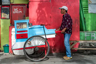 Jakarta peddler pushing a bright stall