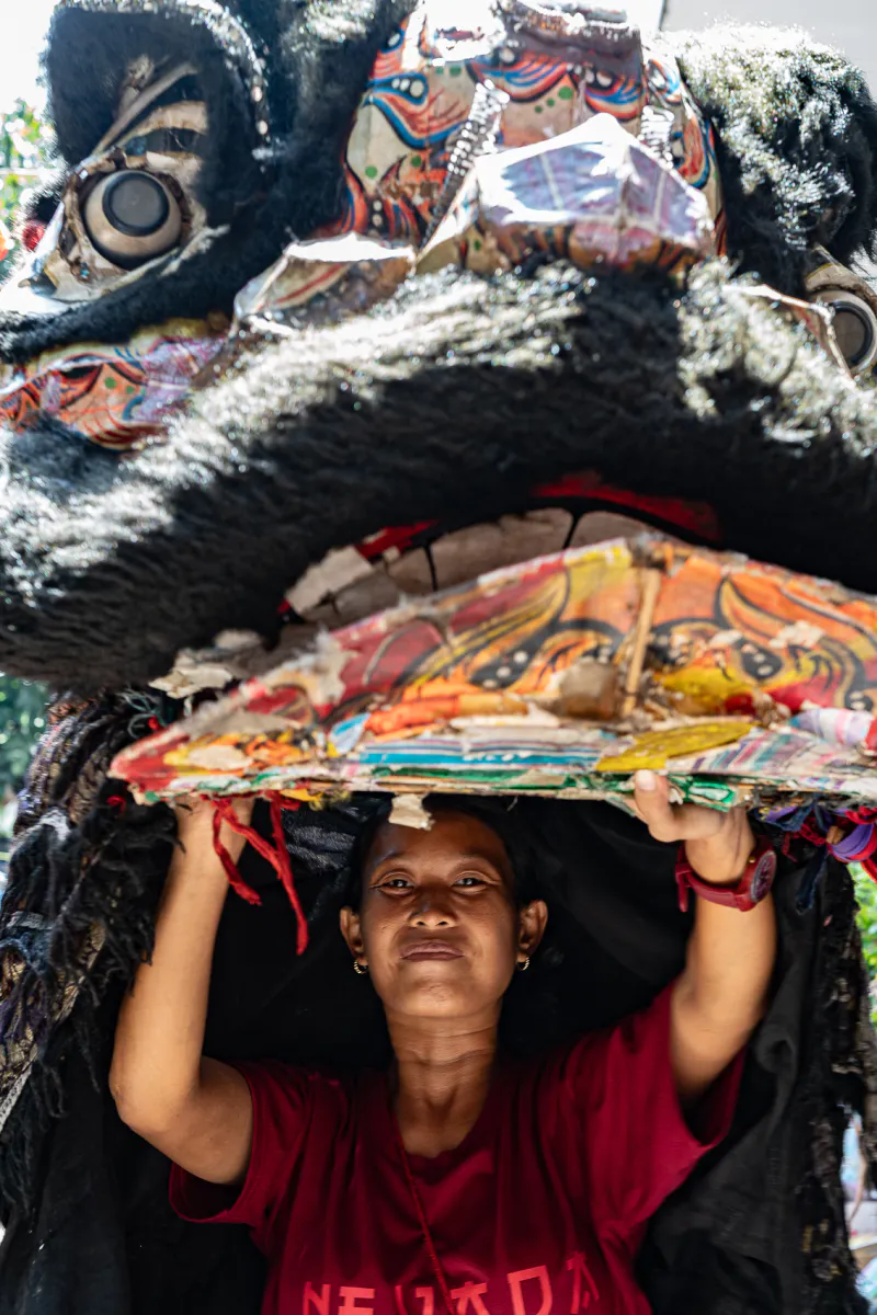 Young woman wearing a lion dance head