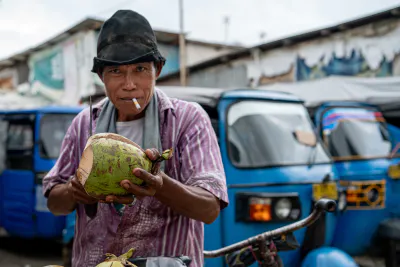 Coconut seller with a cigarette in his mouth