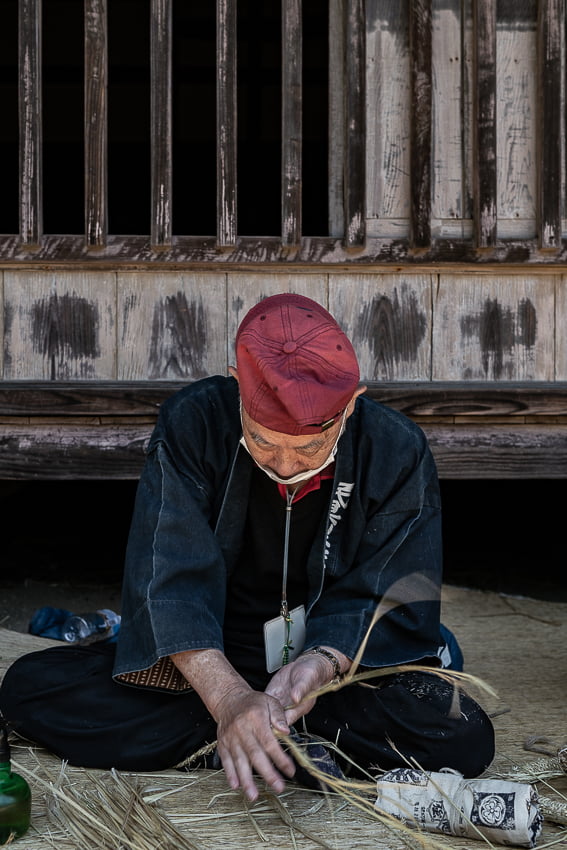 Man making a rope by twisting straw