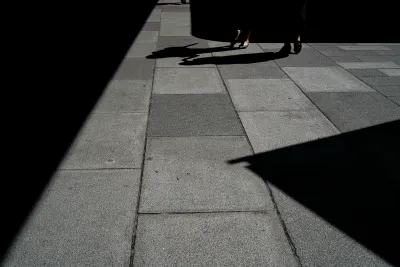 影と影の間を歩く女性の脚