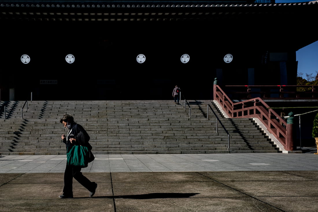 増上寺の本堂前を歩く女性