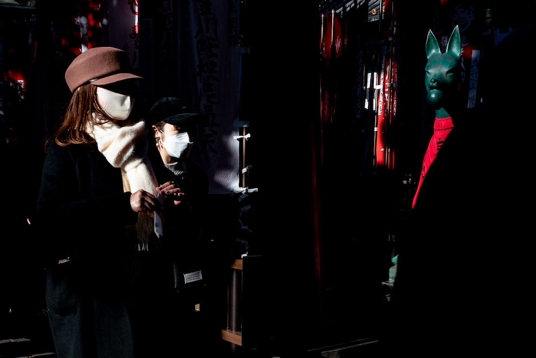 Green fox and masked worshippers at Toyokawa Inari