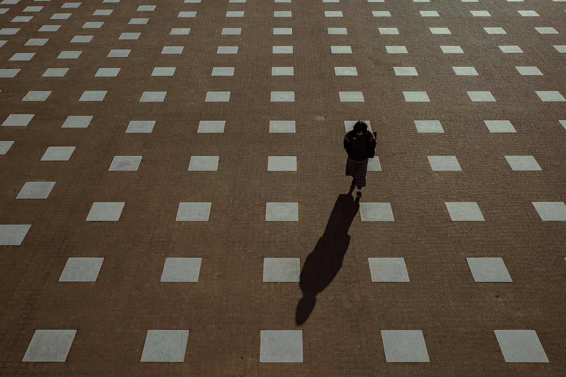 Woman walking while stepping on a square drawn on the ground