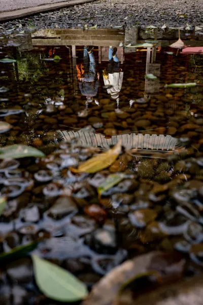 Worshippers reflected in a puddle