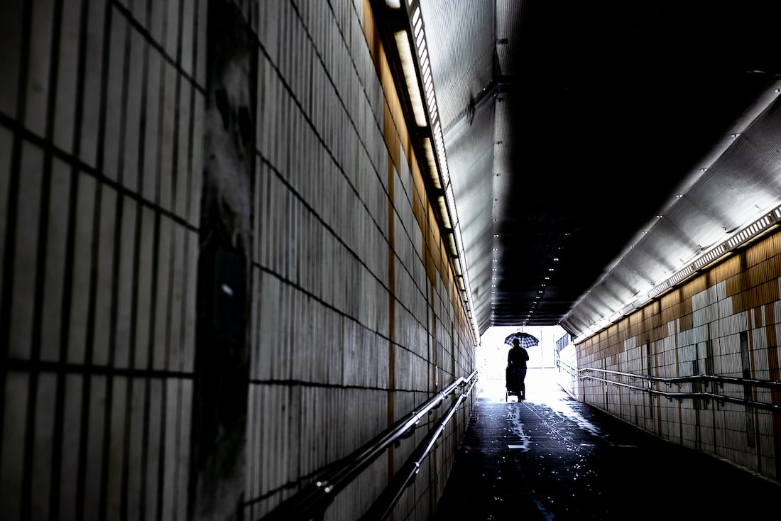 トンネルの中をベビーカーを押して歩く人
