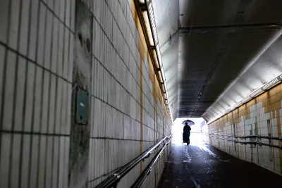 Man pushing strollers through a tunnel