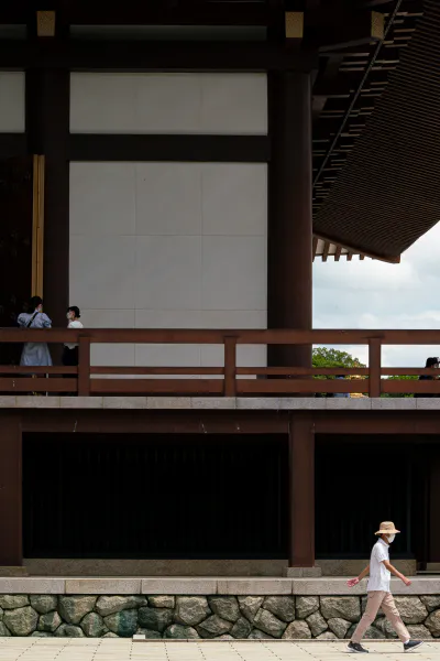 Man walking by the main hall of Naritasan Shinsho-ji Temple