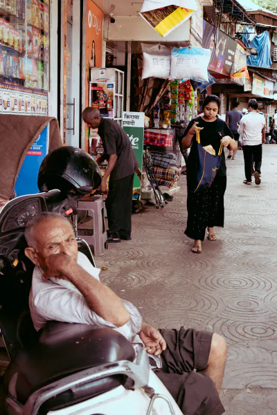 Man leaning against a motor scooter