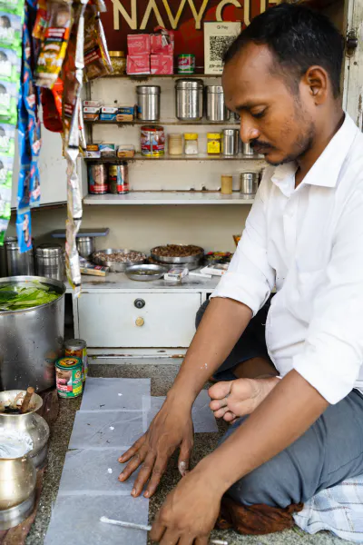 Man selling paan at a kiosk