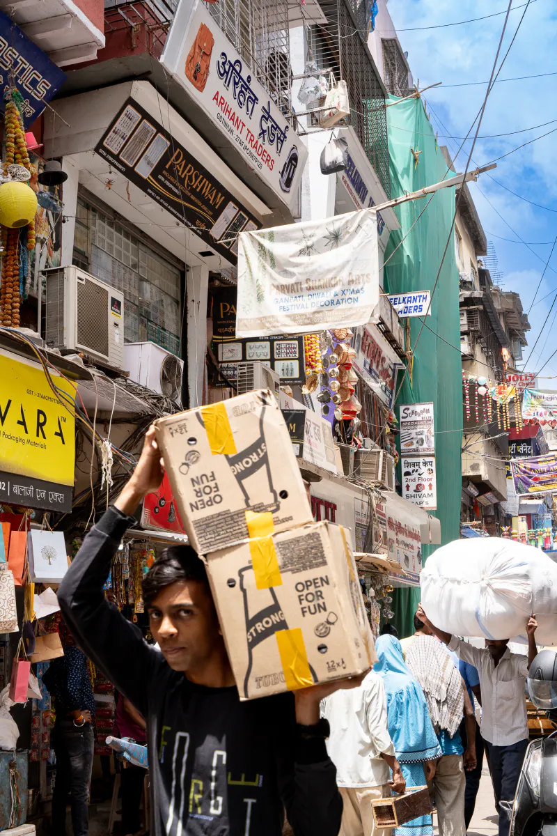 Young man carrying big boxes on his shoulder