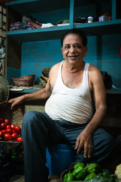 Man selling tomatoes and green peppers