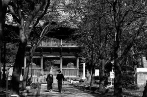 称名寺の仁王門の前を歩くふたり