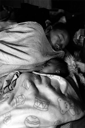 夜市のお店でぐっすり寝るお母さんと赤ちゃん