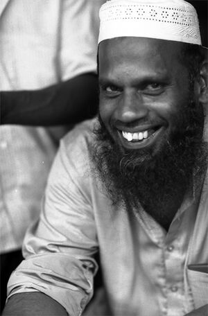 Bearded man grinning in storefront
