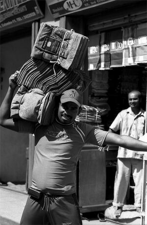 Man carrying textile on shoulder