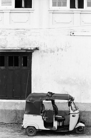 Three wheeler parked against wall