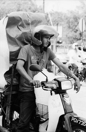 バイクで大きな荷を運ぶ男