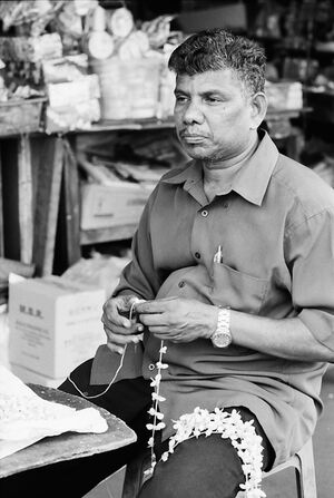 Man weaving garland