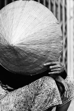 Woman hiding face with conical hat