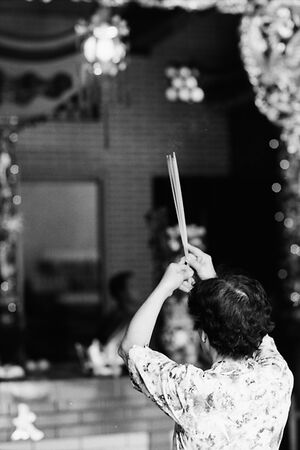 Woman praying with long incense sticks