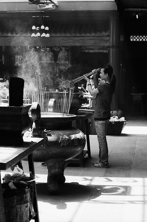 Woman lighting incense sticks on fire
