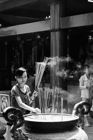 Woman sticking some long incense stick
