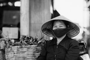 Woman wearing conical hat and black mask