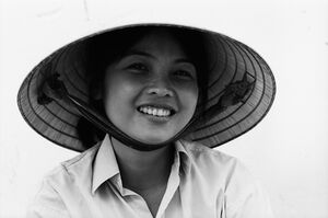 Young woman smiling under conical hat