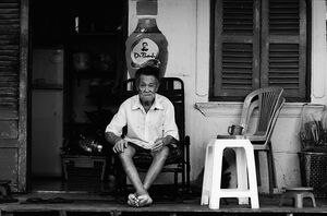 Old man relaxing in storefront