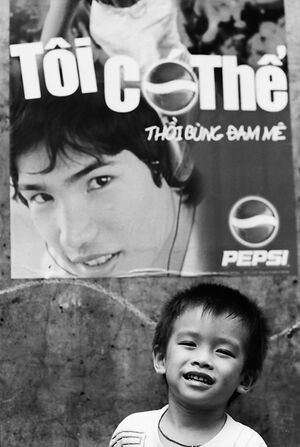 Boy ginning in front of advertisement
