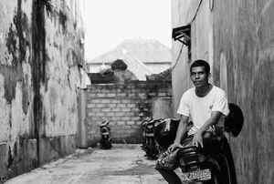 バイクの上に腰掛けいた若い男