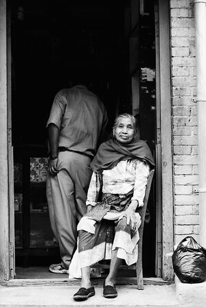 Older woman sitting in front of door