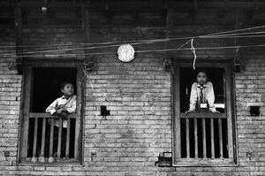 Boys leaning out of window of school