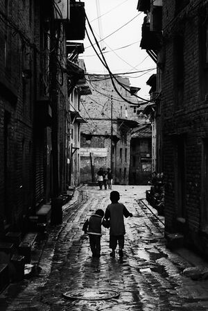 Little brothers walking together in dim lane