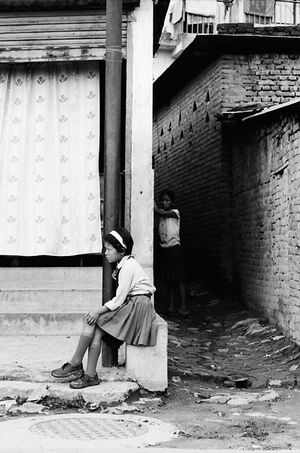 School girl sitting by roadside