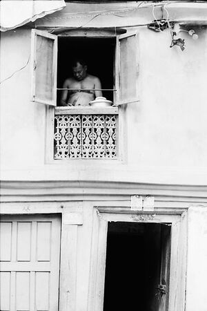Man cooking by upstairs window
