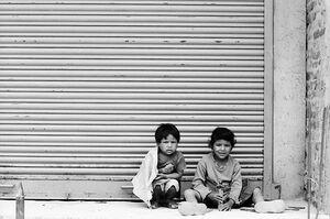 Kids sitting in front of shutter