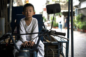 三輪バイクの座席に乗っていた幼い男の子